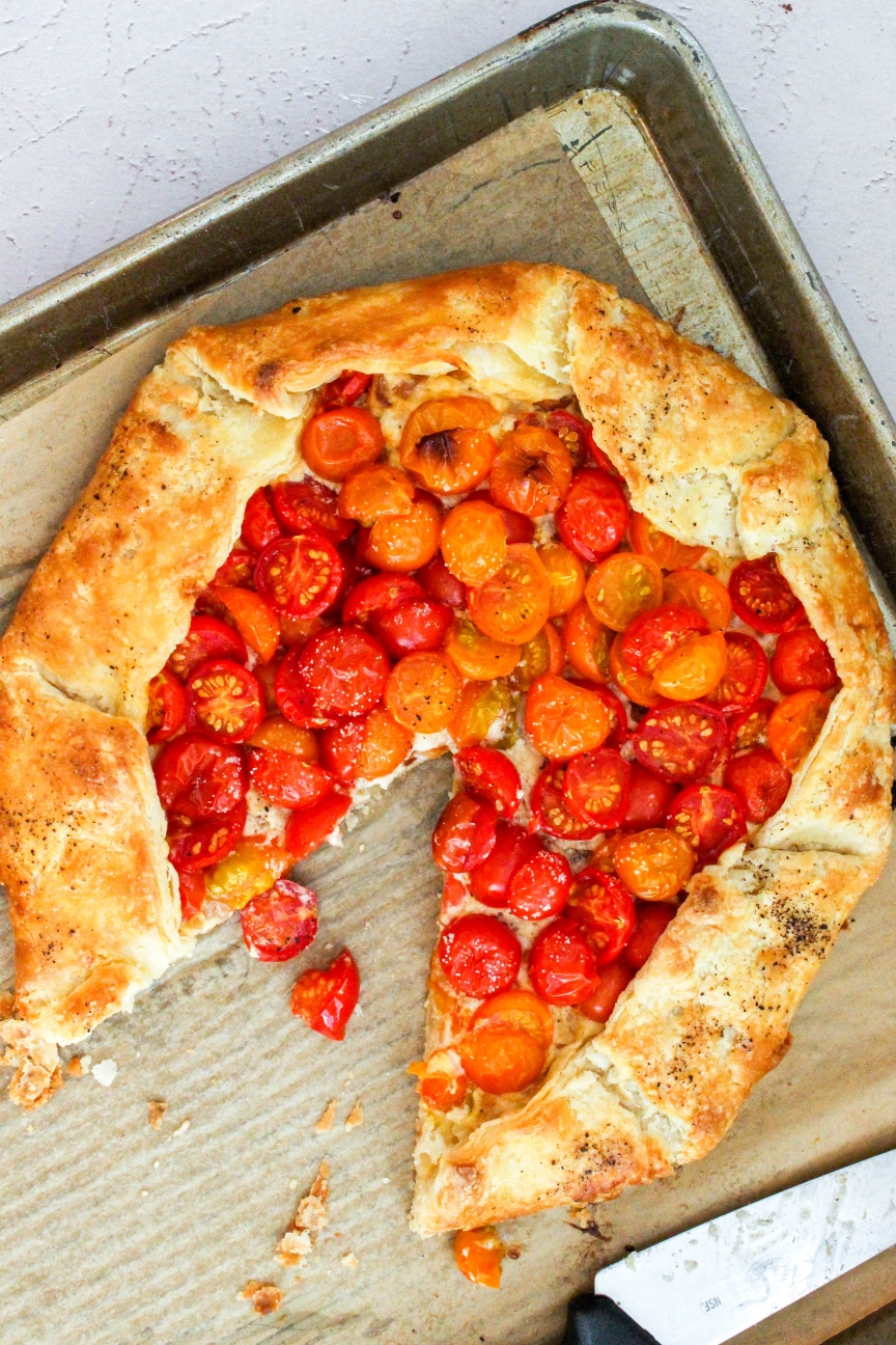 Premium Photo  Homemade galette or savory pie with red and yellow tomatoes  and basil on old newspaper or parchment paper. top view.